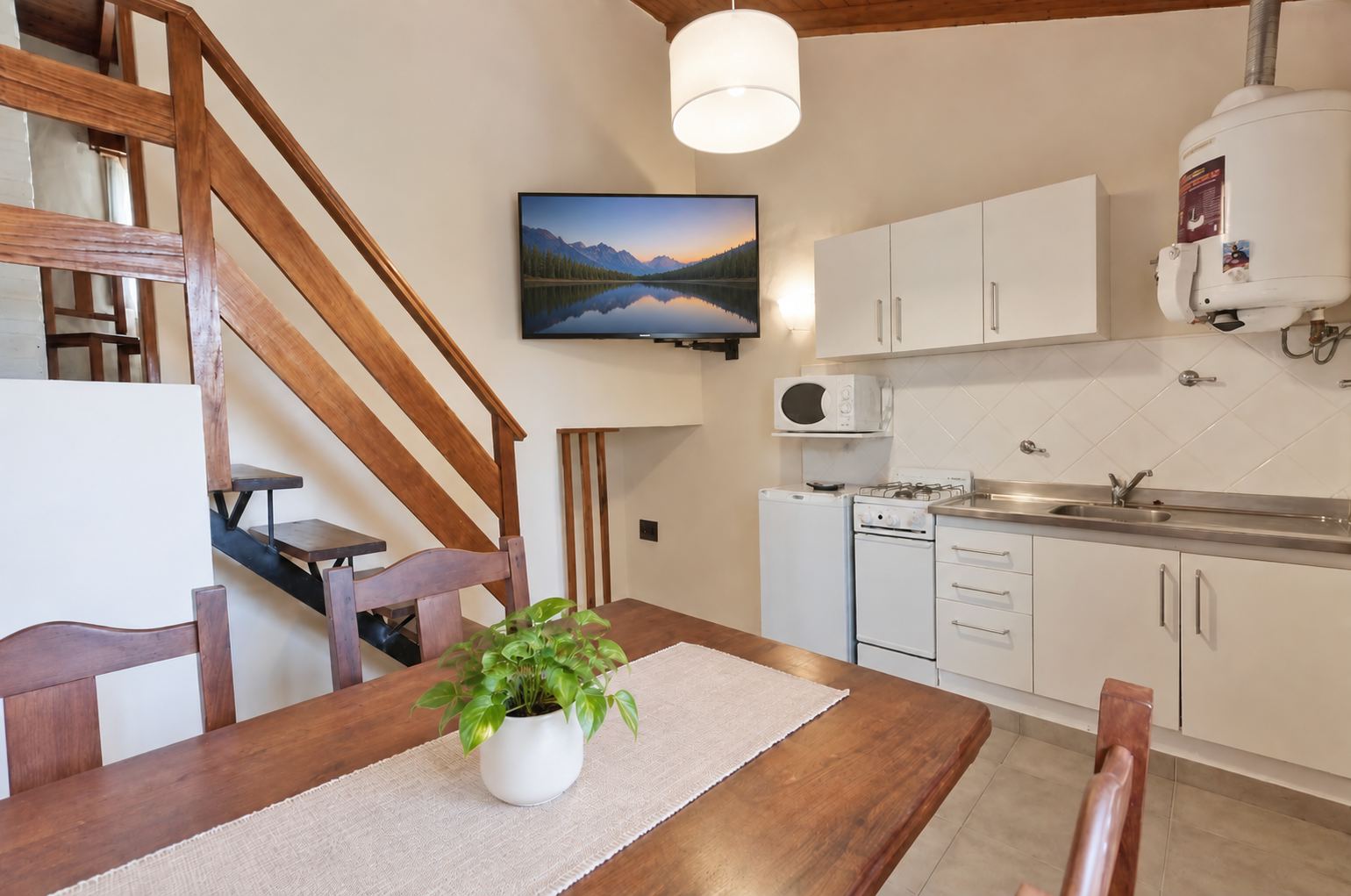 Cocina-comedor con mesa de madera, escalera de madera y Smart TV